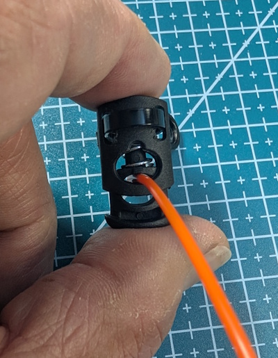 Squeezing the cord lock open around the antenna wire